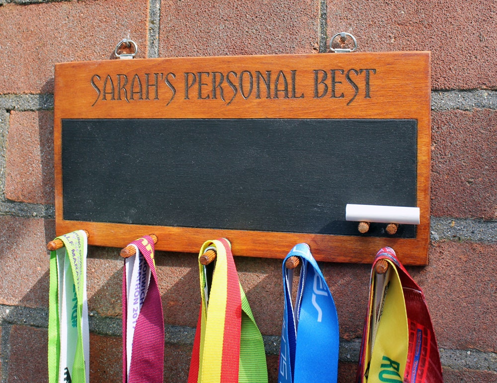 A personalised wooden medal holder with chalk board. A wooden custom medal display with medal hanger with chalk board.