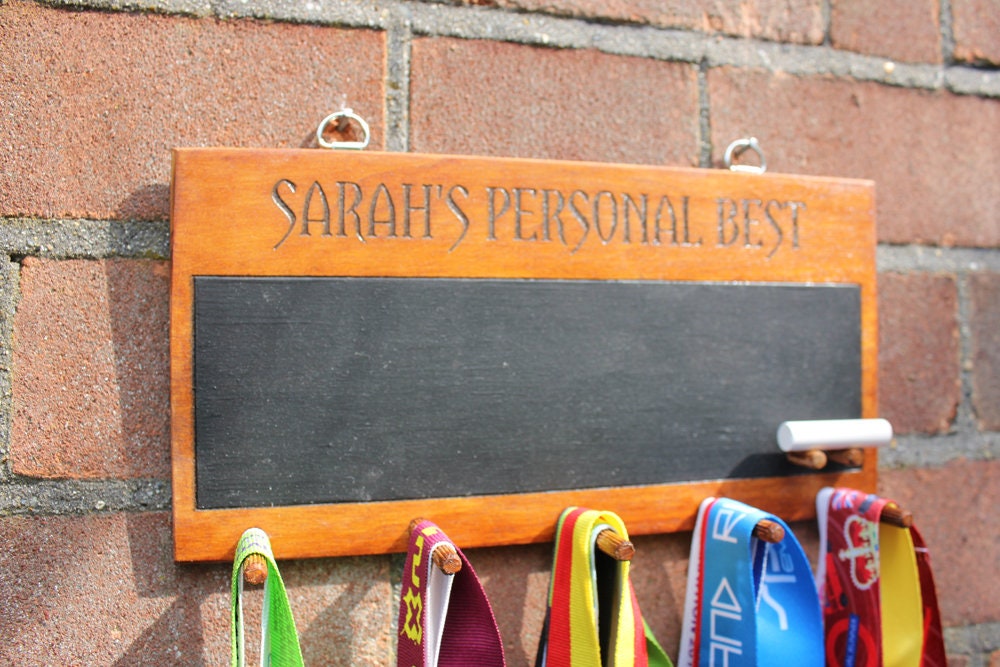 A personalised wooden medal holder with chalk board. A wooden custom medal display with medal hanger with chalk board.