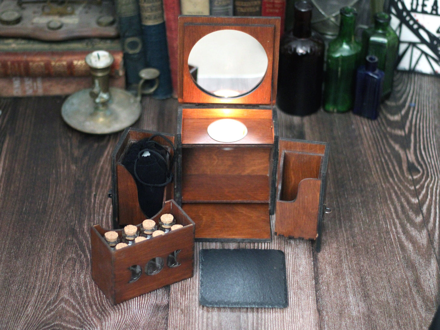 Apothecary cabinet with mirror, drawer of glass potion vials, altar slate and candles for witchcraft.