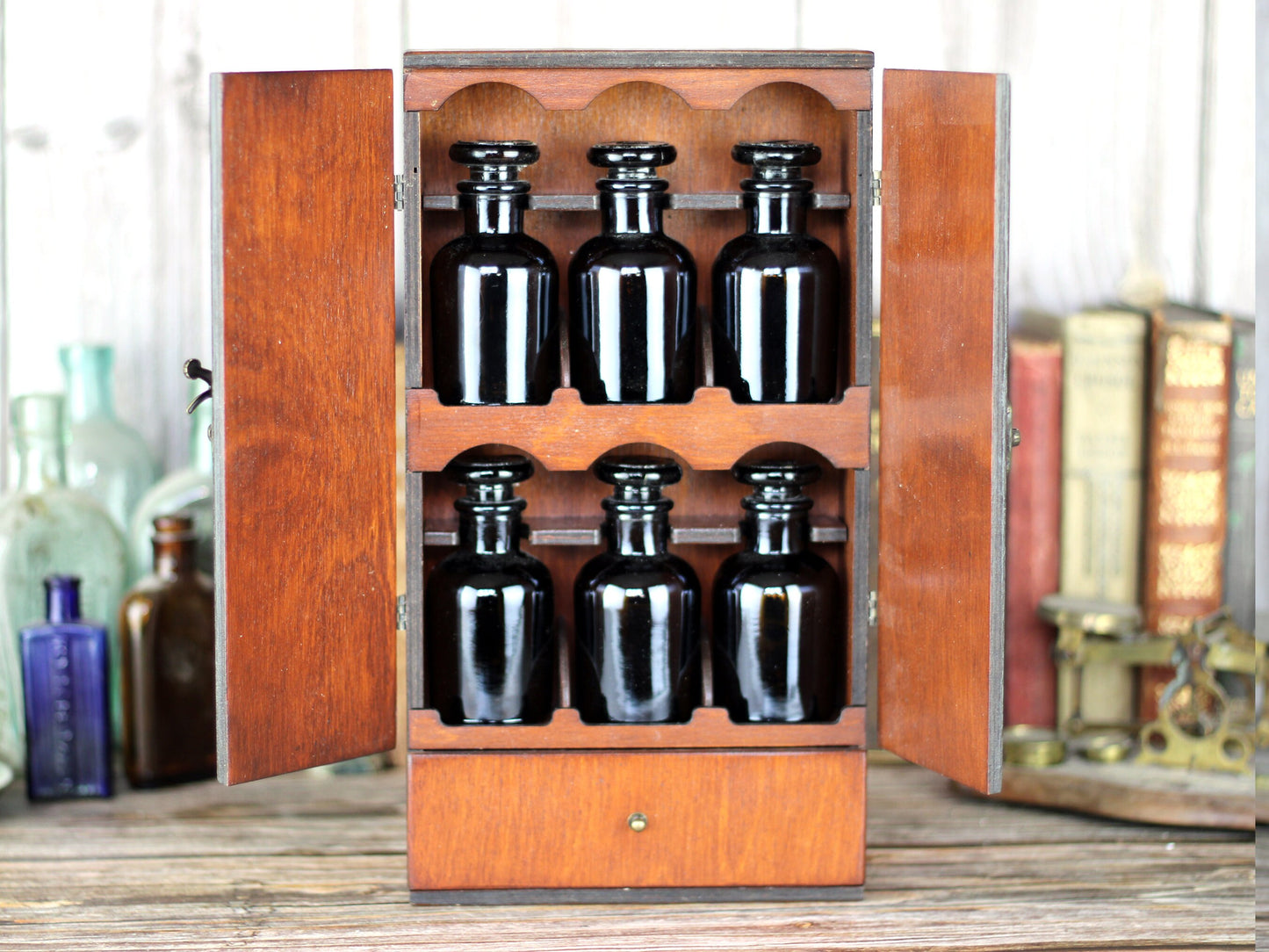 Wooden apothecary cabinet engraved with triple moon goddess and tree of life symbol. Drawer and 6 brown medicine bottles with glass stoppers